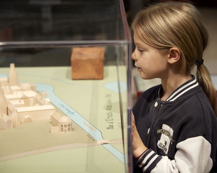 young girl looking at model of factory at wedgwood museum