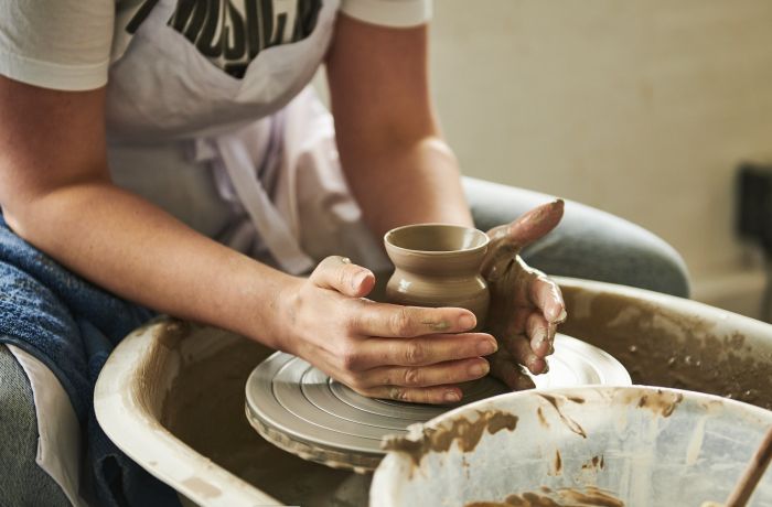 woman making pot on potters wheel on pottery experience at wedgwood