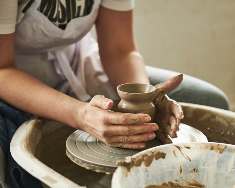 woman making pot on potters wheel on pottery experience at wedgwood