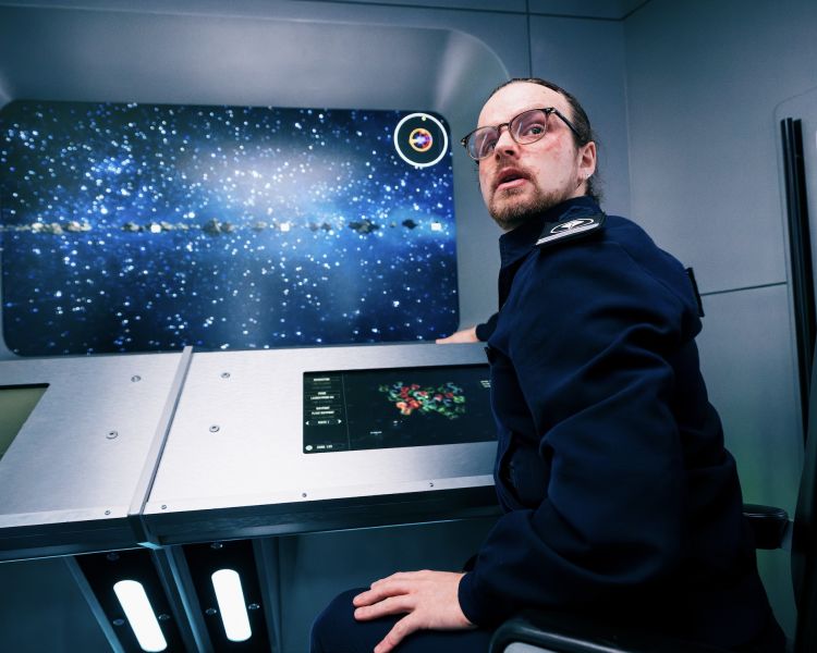 man sitting in front of computer screen on spaceship simulator experience in london