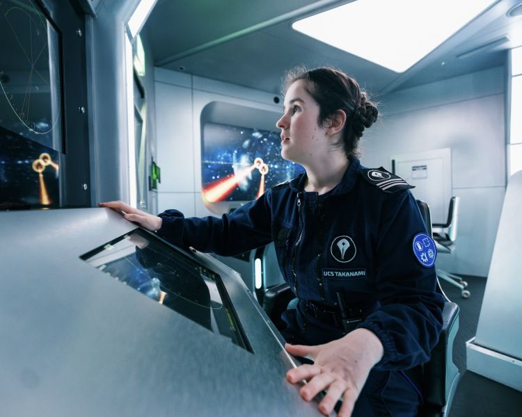 woman looking at screens on spaceship simulator experience in london