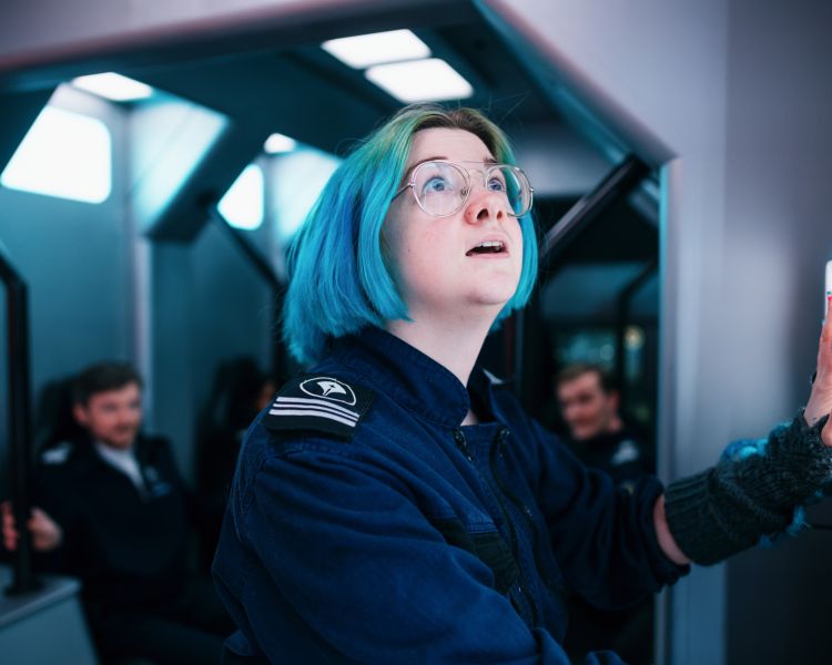 woman opening shuttle doors on immersive spaceship simulator experience