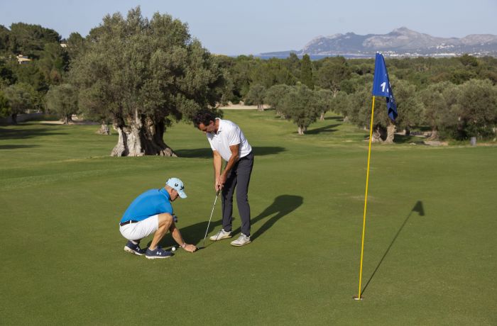 Man receiving golf tuition on a golf course