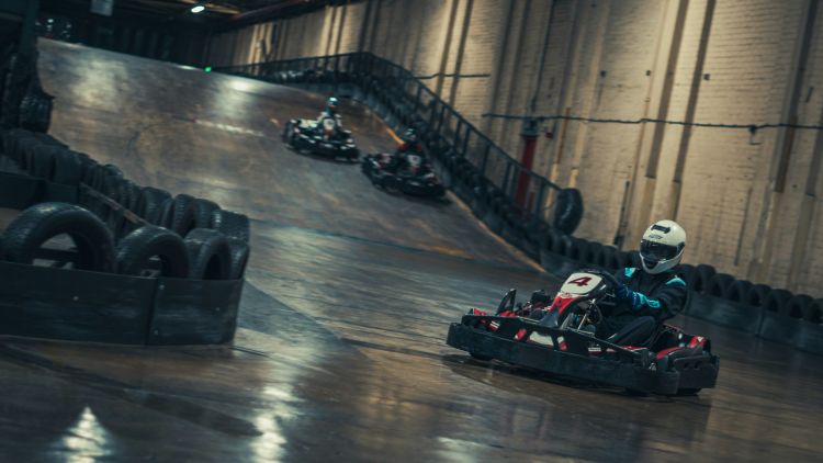 Person in red go kart on indoor race track