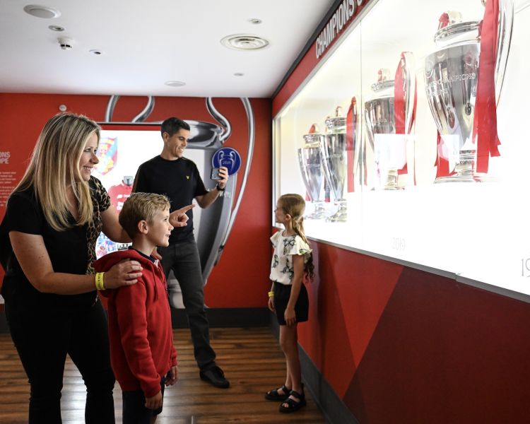 family looking at the trophy exhibit in the museum on the liverpool fc stadium tour