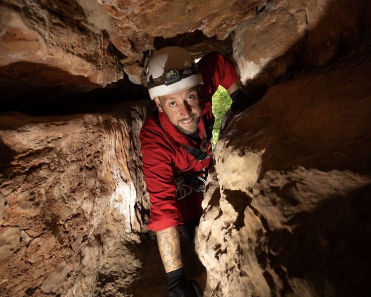 man at entrance to caves on caving experience
