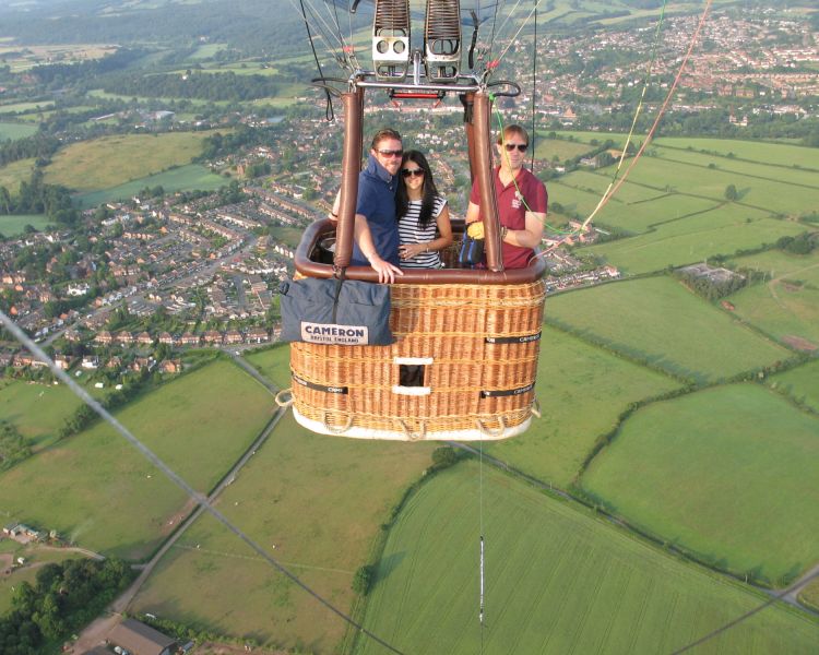 couple on a private hot air balloon ride with countryside views below