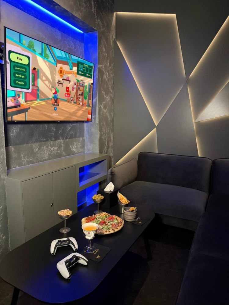 playstation area with pizza and drinks on table at gaming bar in london