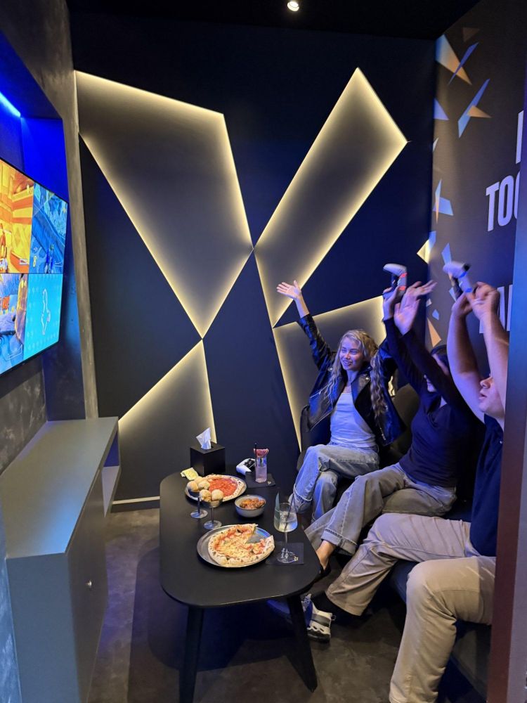 three people playing playstation at gaming bar in london