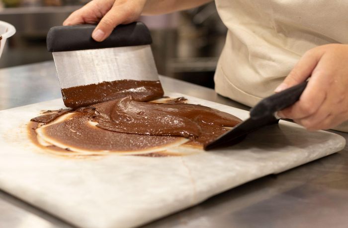 chocolate being tempered on a marble surface