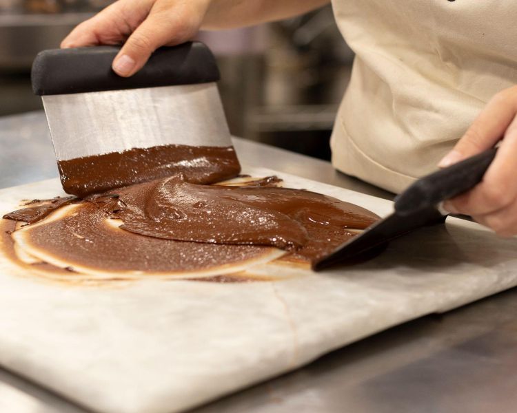 chocolate being tempered on a marble surface