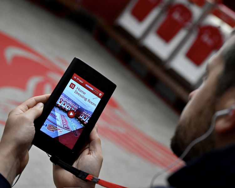 man looking at multimedia device on liverpool fc stadium tour