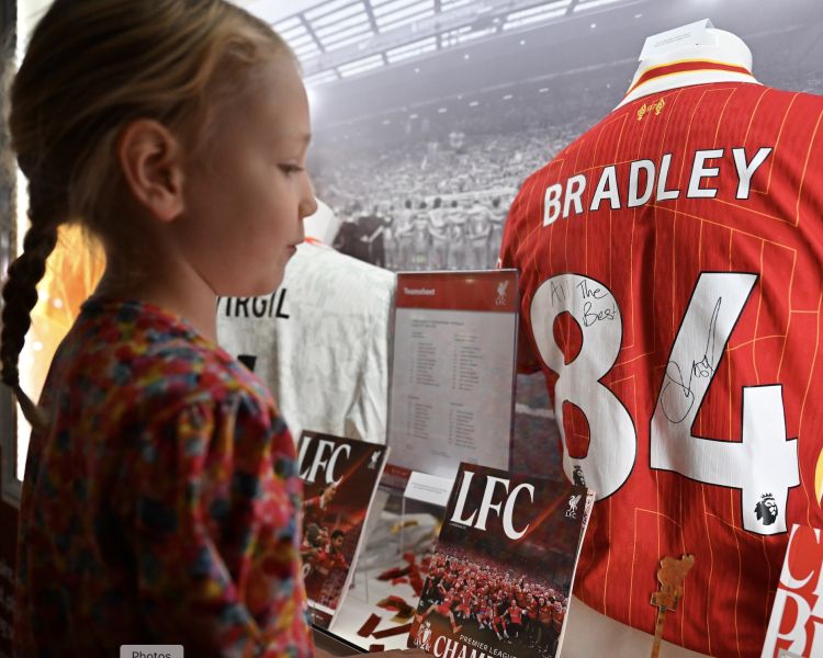 girl looking at signed shirt at liverpool fc museum