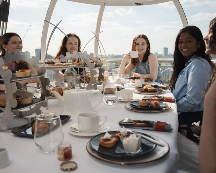 girls sitting around table for afternoon tea in london eye pod