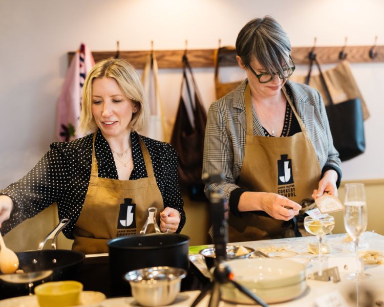 two women cooking at the jamie oliver cookery school
