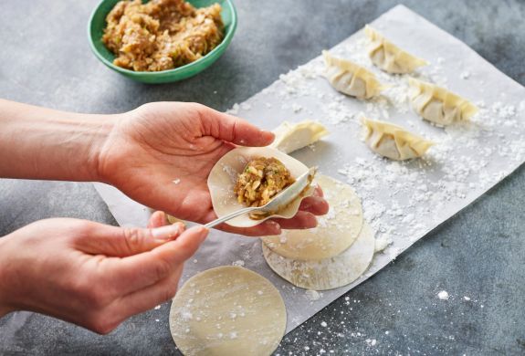 japanese gyoza being filled at jamie oliver cookery school class