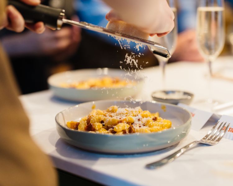 parmesan grated onto bowl of fresh pasta made at jamie oliver cookery school