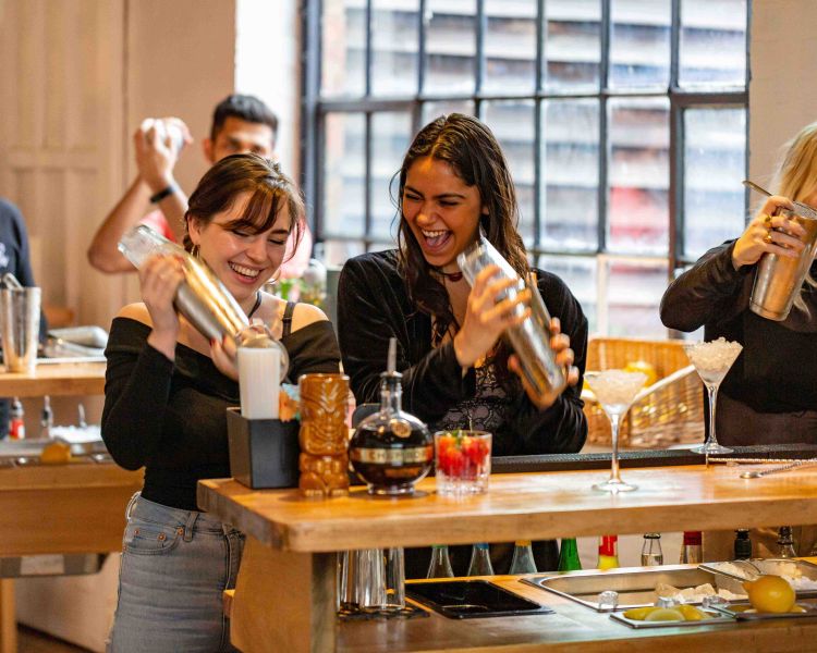 ladies shaking cocktails at cocktail class in london