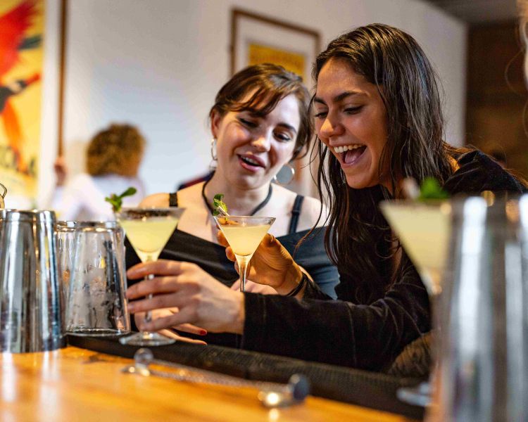 ladies at their bar station making cocktails at a class in london