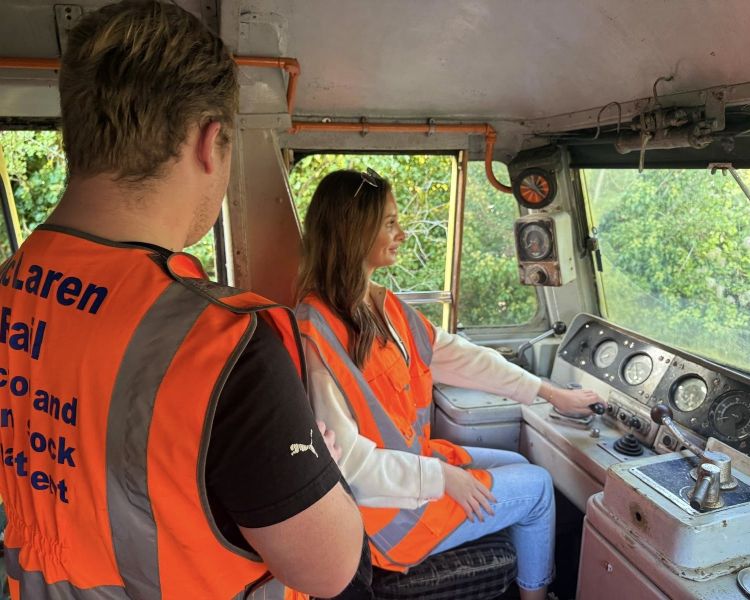 woman learning how to drive a diesel train with instructor on a train driving experience