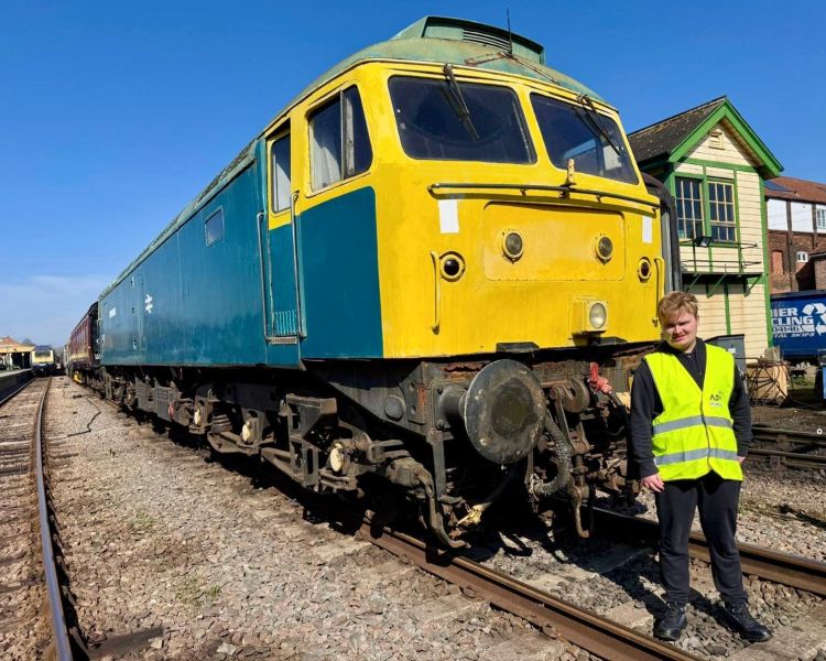 man standing in front of diesel train on a train driving experience