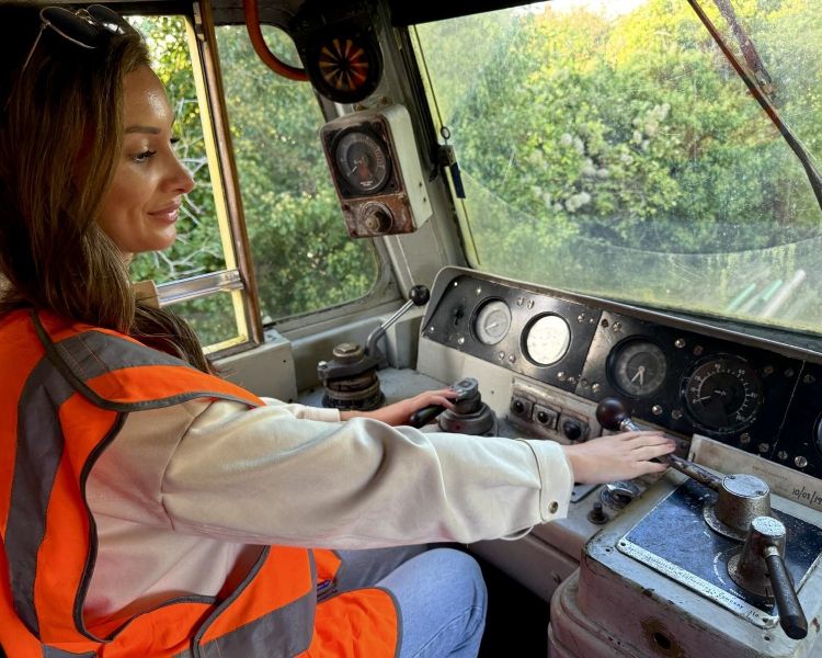 woman sitting in drivers seat of diesel train on a train driving experience