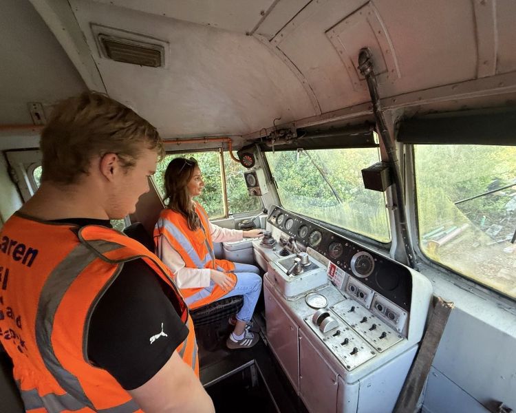 instructor showing woman how to drive a train