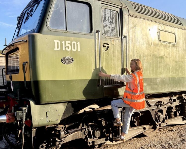 woman climbing up to train door on a train driving experience
