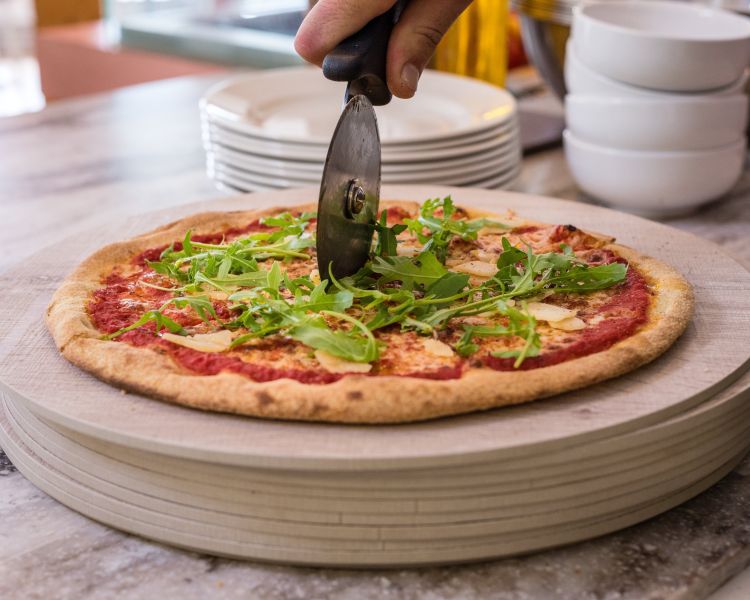 pizza being cut at the pizzeria at blenheim palace