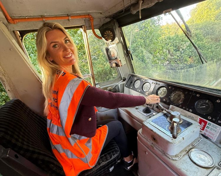 woman sitting in drivers seat of diesel train on a train driving experience