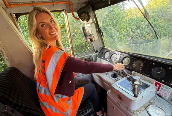 woman sitting in drivers seat of diesel train on a train driving experience
